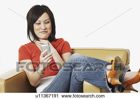 Stock Image - Close-up of a young woman operating a mobile phone. Fotosearch
