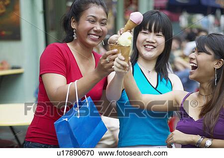 Close-up of three young women holding ice-cream cones View Large Photo Image Stock Image - Close-up of three young women holding ice-cream cones. Fotosearch