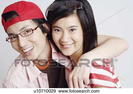 Stock Photo - Portrait of a young woman and a mid adult man smiling. Fotosearch