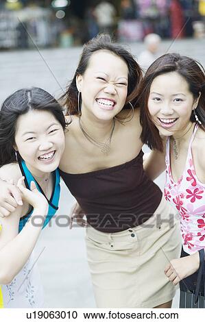 Stock Image - Portrait of three young women smiling. Fotosearch