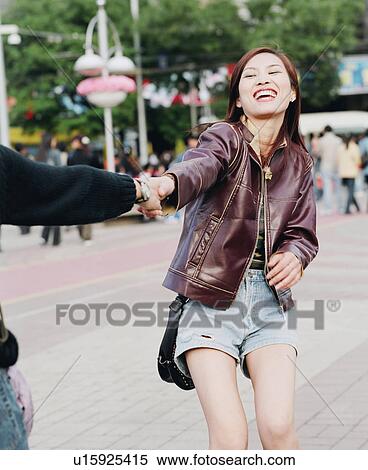 Stock Photography - Young woman holding the hand of another person. Fotosearch