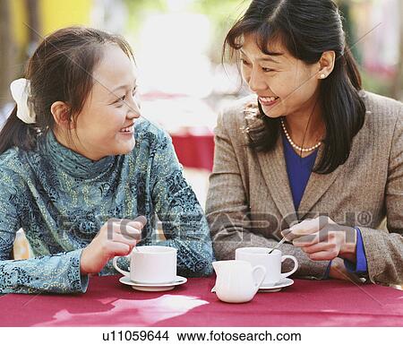 Close-up of two young women sitting in a restaurant View Large Photo Image Picture - Close-up of two young women sitting in a restaurant. Fotosearch