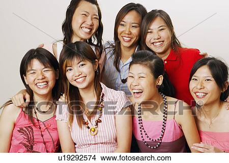 Picture - Group of young women sitting together and looking cheerful. Fotosearch