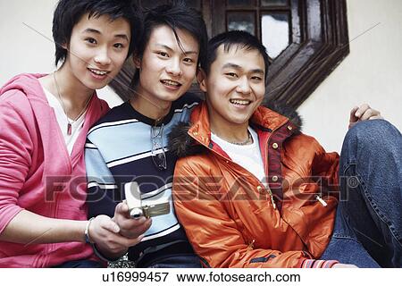 Portrait of a teenage boy smiling with two young men View Large Photo Image Stock Photo - Portrait of a teenage boy smiling with two young men. Fotosearch