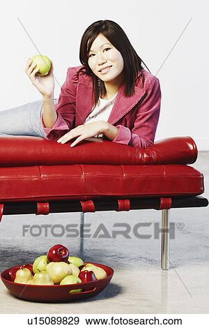 Portrait of a young woman holding a green apple View Large Photo Image Stock Photo - Portrait of a young woman holding a green apple. Fotosearch