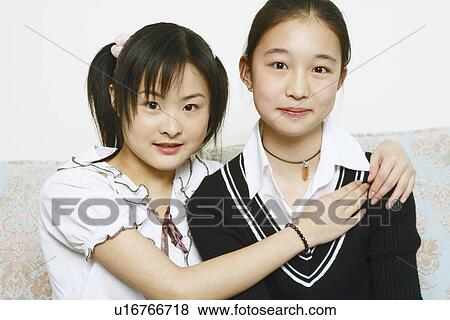 Portrait of a young woman hugging her friend View Large Photo Image Stock Photo - Portrait of a young woman hugging her friend. Fotosearch