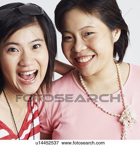 Portrait of two young women looking cheerful View Large Photo Image Stock Photo - Portrait of two young women looking cheerful. Fotosearch