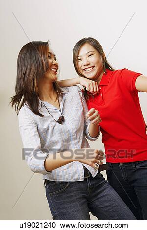 Stock Image - Portrait of two young women smiling. Fotosearch