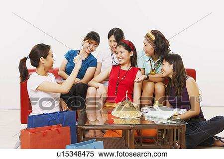 Stock Photography - Young woman celebrating her birthday with her friends. Fotosearch