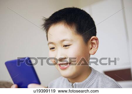 Stock Photo - Close-up of a boy playing a video game. Fotosearch