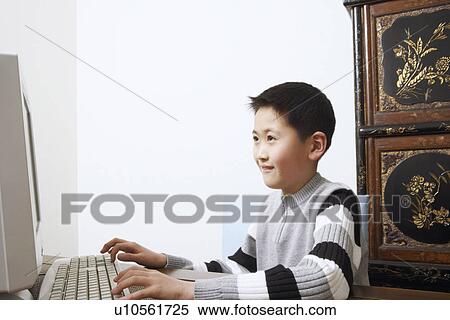 Close-up of a boy using a computer View Large Photo Image Stock Photography - Close-up of a boy using a computer. Fotosearch