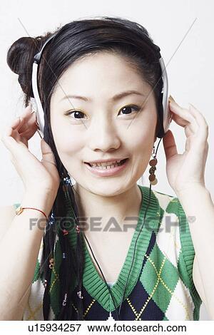 Close-up of a teenage girl listening to music smiling View Large Photo Image Stock Photo - Close-up of a teenage girl listening to music smiling. Fotosearch