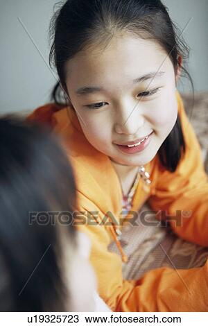 Stock Image - High angle view of two girls talking. Fotosearch