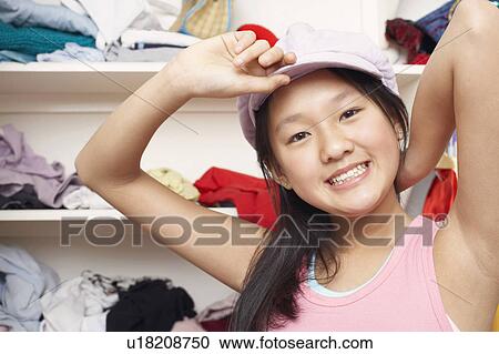 Stock Image - Portrait of a girl holding a cap. Fotosearch