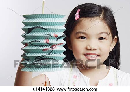 Stock Photo - Portrait of a girl holding a Chinese lantern and smiling. Fotosearch