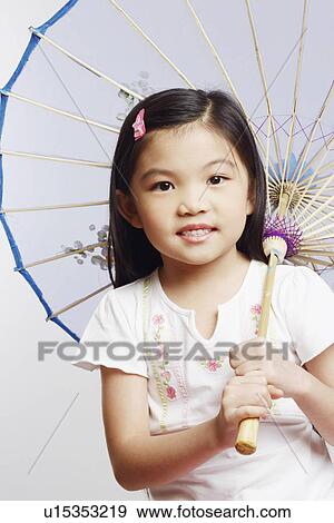 Portrait of a girl holding a parasol and smiling View Large Photo Image Stock Photo - Portrait of a girl holding a parasol and smiling. Fotosearch