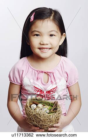 Portrait of a girl holding eggs in a bird's nest View Large Photo Image Stock Image - Portrait of a girl holding eggs in a bird's nest. Fotosearch