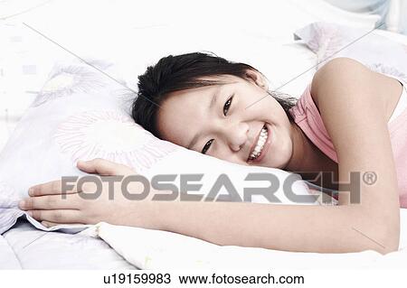 Portrait of a girl lying on the bed View Large Photo Image Stock Image - Portrait of a girl lying on the bed. Fotosearch