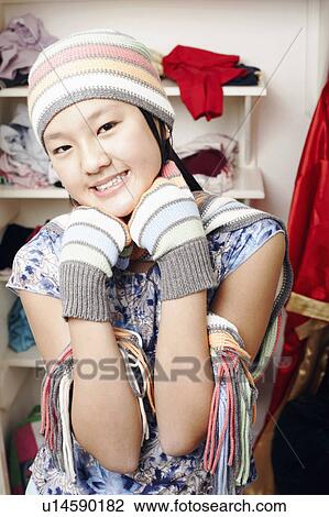 Stock Image - Portrait of a girl wearing a hat and gloves. Fotosearch