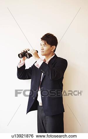 Stock Photograph - Businessman holding a pair of binoculars. Fotosearch