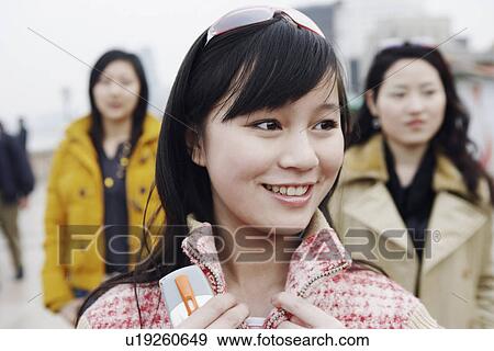 Close-up of a young woman looking away View Large Photo Image Stock Photo - Close-up of a young woman looking away. Fotosearch