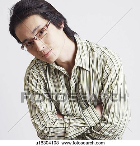 Stock Photo - Portrait of a mid adult man sitting with his arms crossed. Fotosearch