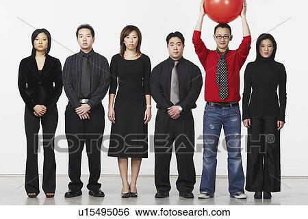 Portrait of a young man standing holding a ball with a group of business executives View Large Photo Image Stock Photograph - Portrait of a young man standing holding a ball with a group of business executives. Fotosearch