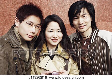 Portrait of a young woman and two young men smiling View Large Photo Image Stock Photo - Portrait of a young woman and two young men smiling. Fotosearch