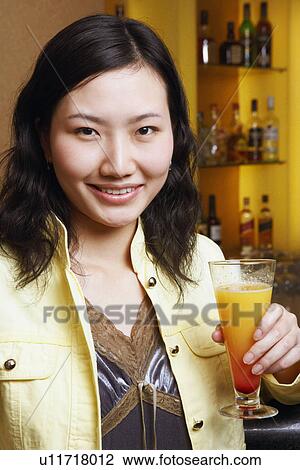 Portrait of a young woman holding a glass View Large Photo Image Stock Image - Portrait of a young woman holding a glass. Fotosearch