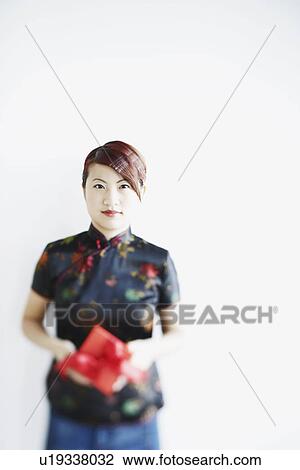 Portrait of a young woman holding a gift in her hands View Large Photo Image Stock Image - Portrait of a young woman holding a gift in her hands. Fotosearch
