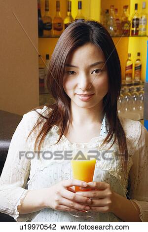 Portrait of a young woman holding a glass View Large Photo Image Stock Image - Portrait of a young woman holding a glass. Fotosearch