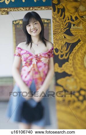 Portrait of a young woman leaning against a wall View Large Photo Image Stock Image - Portrait of a young woman leaning against a wall. Fotosearch