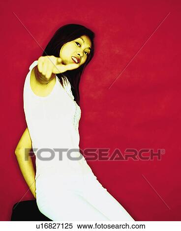 Stock Photography - Portrait of a young woman pointing her finger. Fotosearch