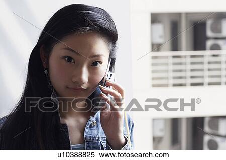 Portrait of a young woman using a mobile phone View Large Photo Image Stock Photography - Portrait of a young woman using a mobile phone. Fotosearch