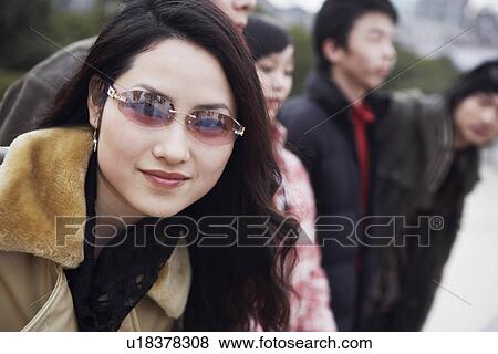 Stock Photo - Portrait of a young woman wearing sunglasses. Fotosearch