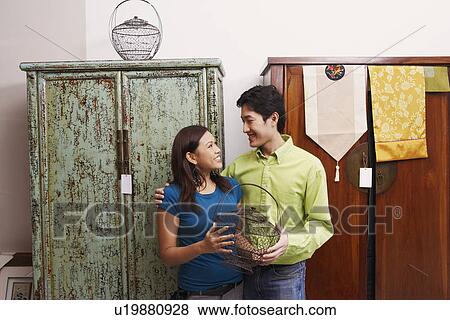 Close-up of a young couple holding a cage and looking at each other View Large Photo Image Stock Photo - Close-up of a young couple holding a cage and looking at each other. Fotosearch
