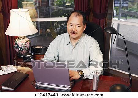 Stock Image - High angle view of a senior man using a laptop. Fotosearch