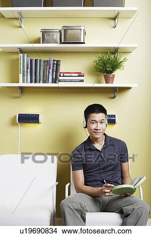 Picture - Portrait of a young man listening to music on headphones. Fotosearch
