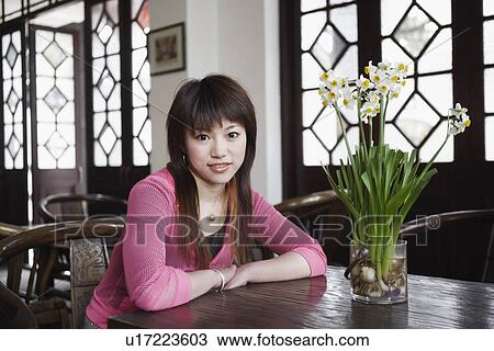 Portrait of a young woman sitting in a restaurant smiling View Large Photo Image Stock Image - Portrait of a young woman sitting in a restaurant smiling. Fotosearch