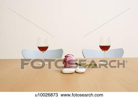 Stock Image - Two glasses of red wine with a lotus on the table. Fotosearch