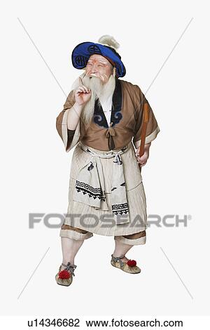 Stock Image - Mid adult man standing holding an oar. Fotosearch