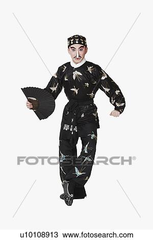 Stock Image - Portrait of a male Chinese opera performer holding a fan. Fotosearch