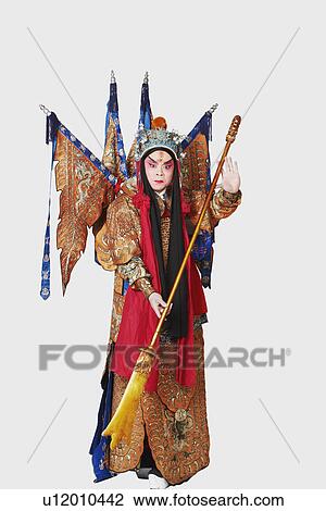 Stock Image - Portrait of a male Chinese opera performer holding a weapon. Fotosearch