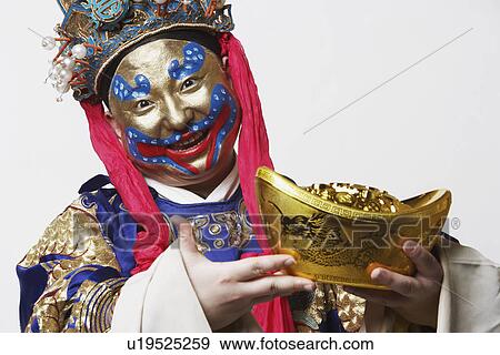 Stock Photo - Portrait of a male Chinese opera performer holding a bowl full of gold coins. Fotosearch