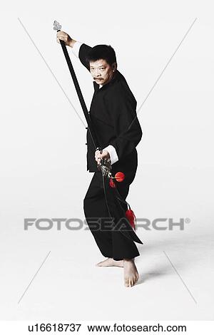 Stock Photo - Portrait of a mature man gesturing with a weapon. Fotosearch