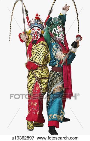 Stock Photo - Side profile of two male Chinese opera performers gesturing with weapons. Fotosearch