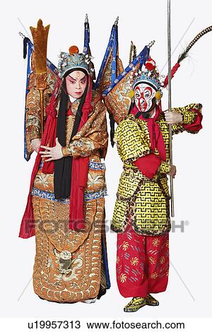 Stock Image - Two male Chinese opera performers gesturing with weapons. Fotosearch