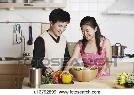 Close-up of a young man standing with a mid adult woman in the kitchen View Large Photo Image Stock Photo - Close-up of a young man standing with a mid adult woman in the kitchen. Fotosearch