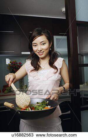 Portrait of a young woman cooking View Large Photo Image Stock Image - Portrait of a young woman cooking. Fotosearch