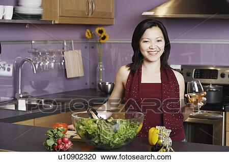 Portrait of a young woman holding a wineglass smiling in the kitchen View Large Photo Image Stock Image - Portrait of a young woman holding a wineglass smiling in the kitchen. Fotosearch
